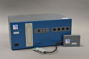 A NPDP-GDEV console and the GameCube EXI-to-USB Adapter. The "Beta release" sticker on both the console and adapter indicates that they have or had pre-final internals.